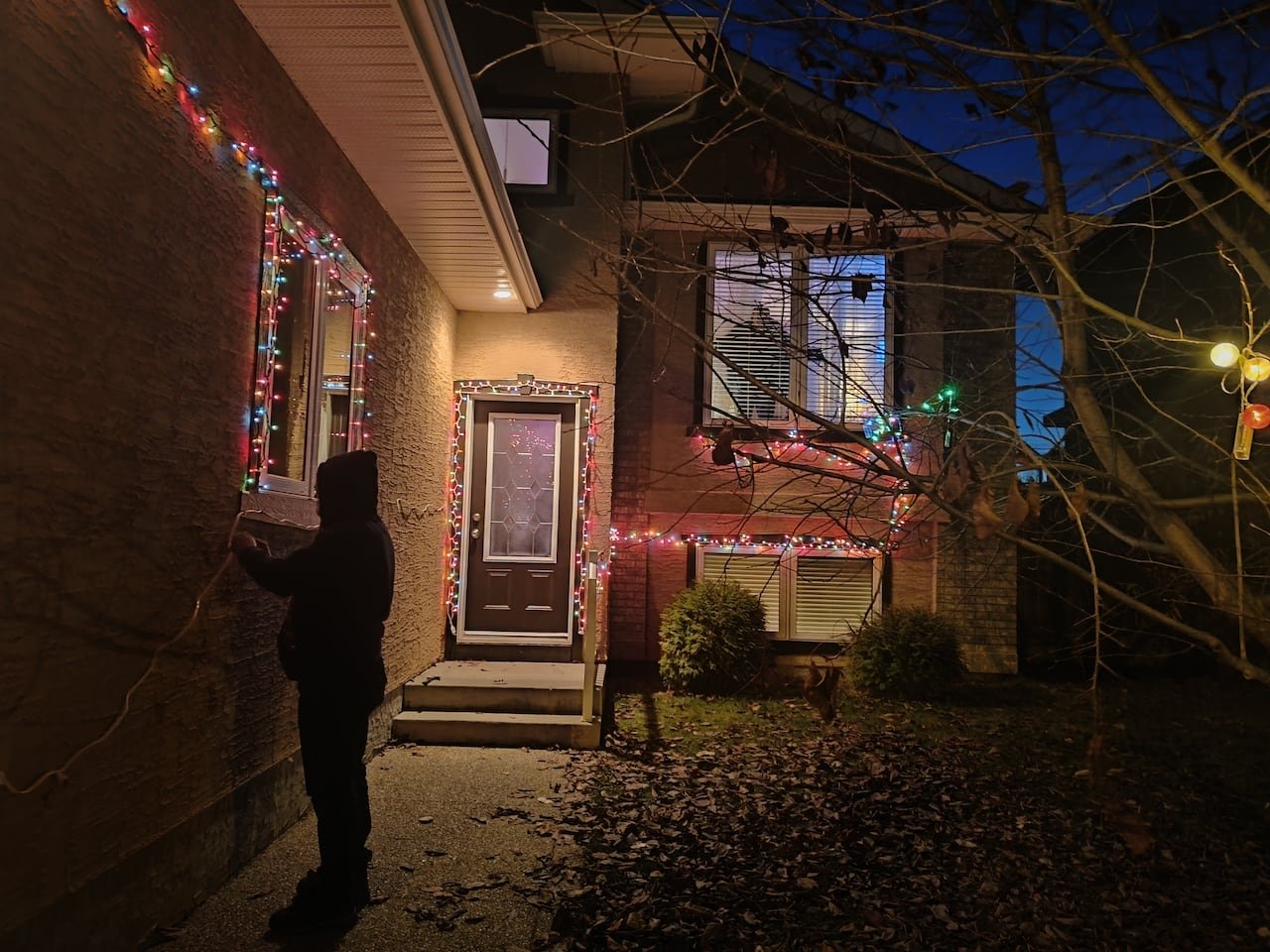 A house illuminated with Christmas lights at night.