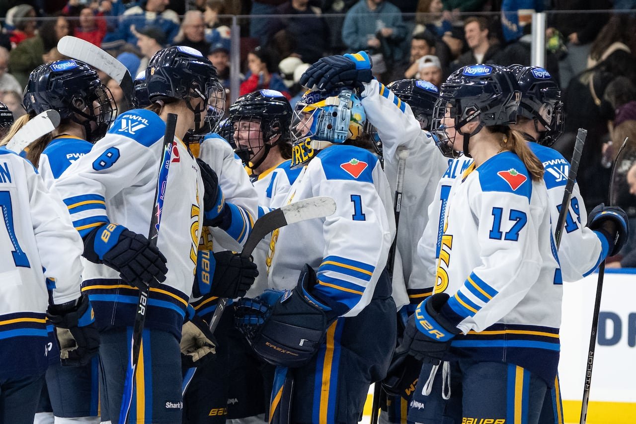 default-208 A group of women in Toronto Sceptres jerseys celebrating on the ice.